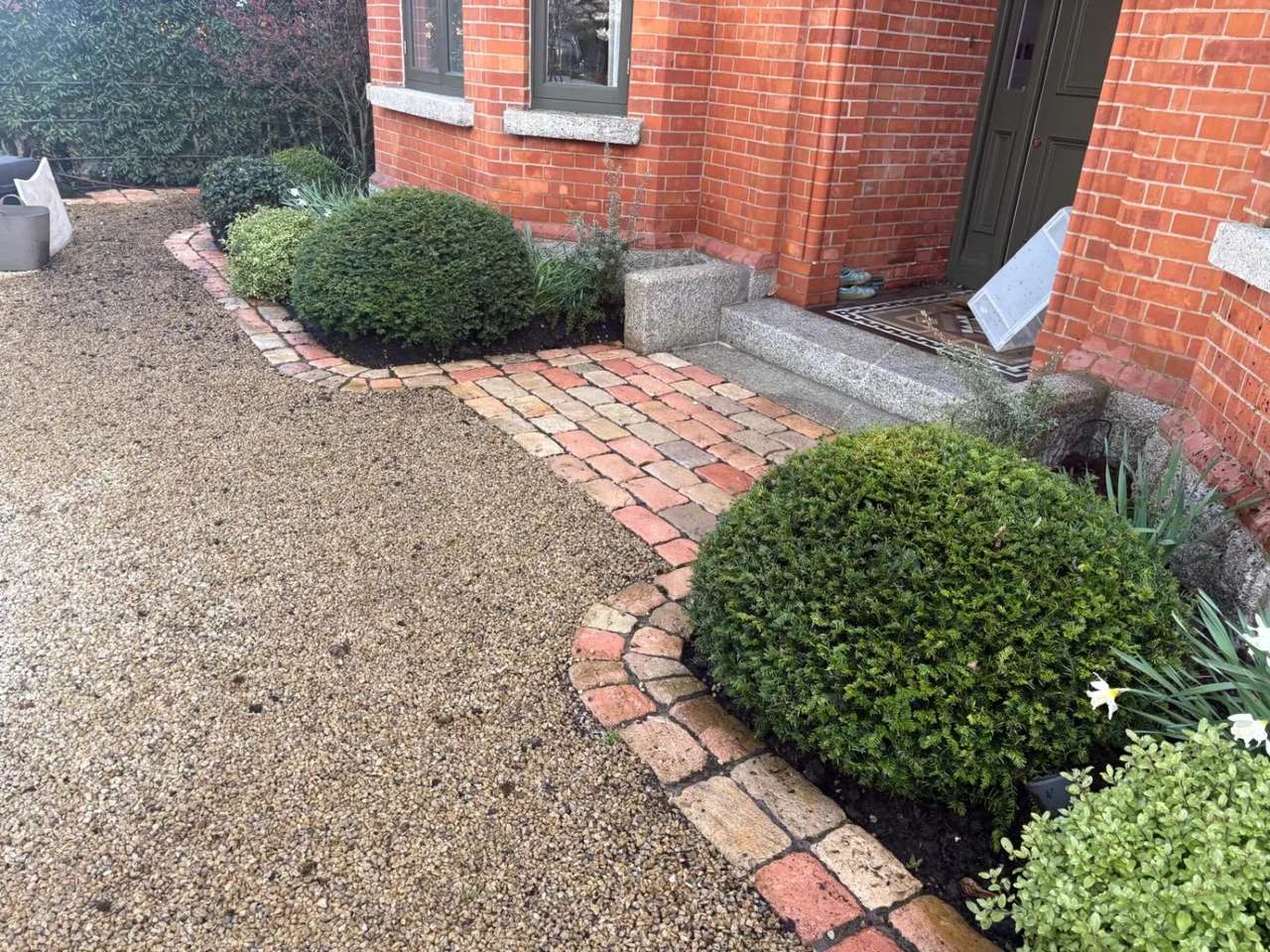 Cobble edged front path of a red-brick house, cleaned by Costello Cleaning Services